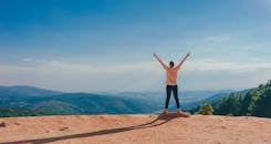 Person in Beige Top on Mountain Cliff